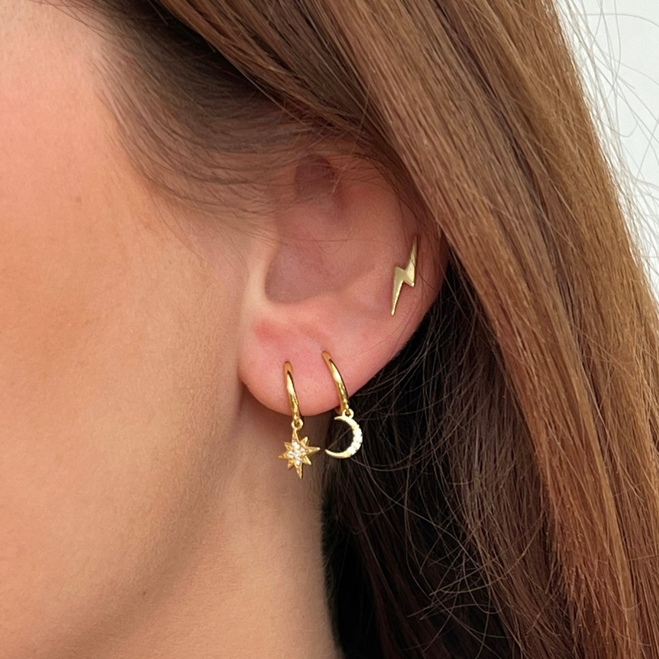 18kt gold plated sterling silver star and moon celestial huggie hoop earrings with cubic zirconia detail by Angel Rocks