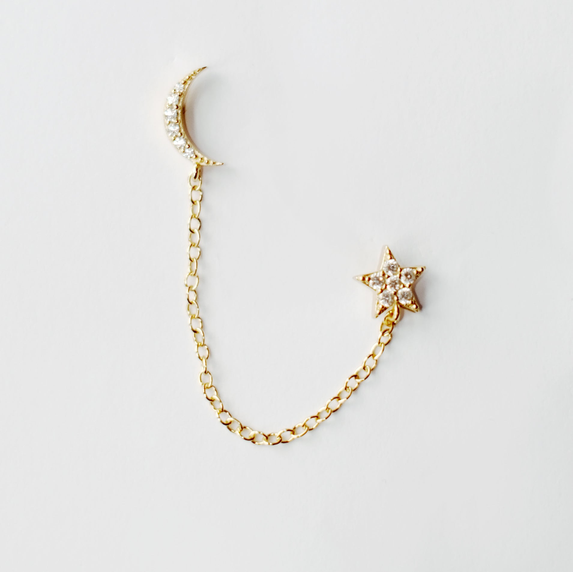 18kt gold plated sterling silver star and moon chain drop stud earrings with delicate diamanté detail and connecting chain for multiple piercings by Angel Rocks