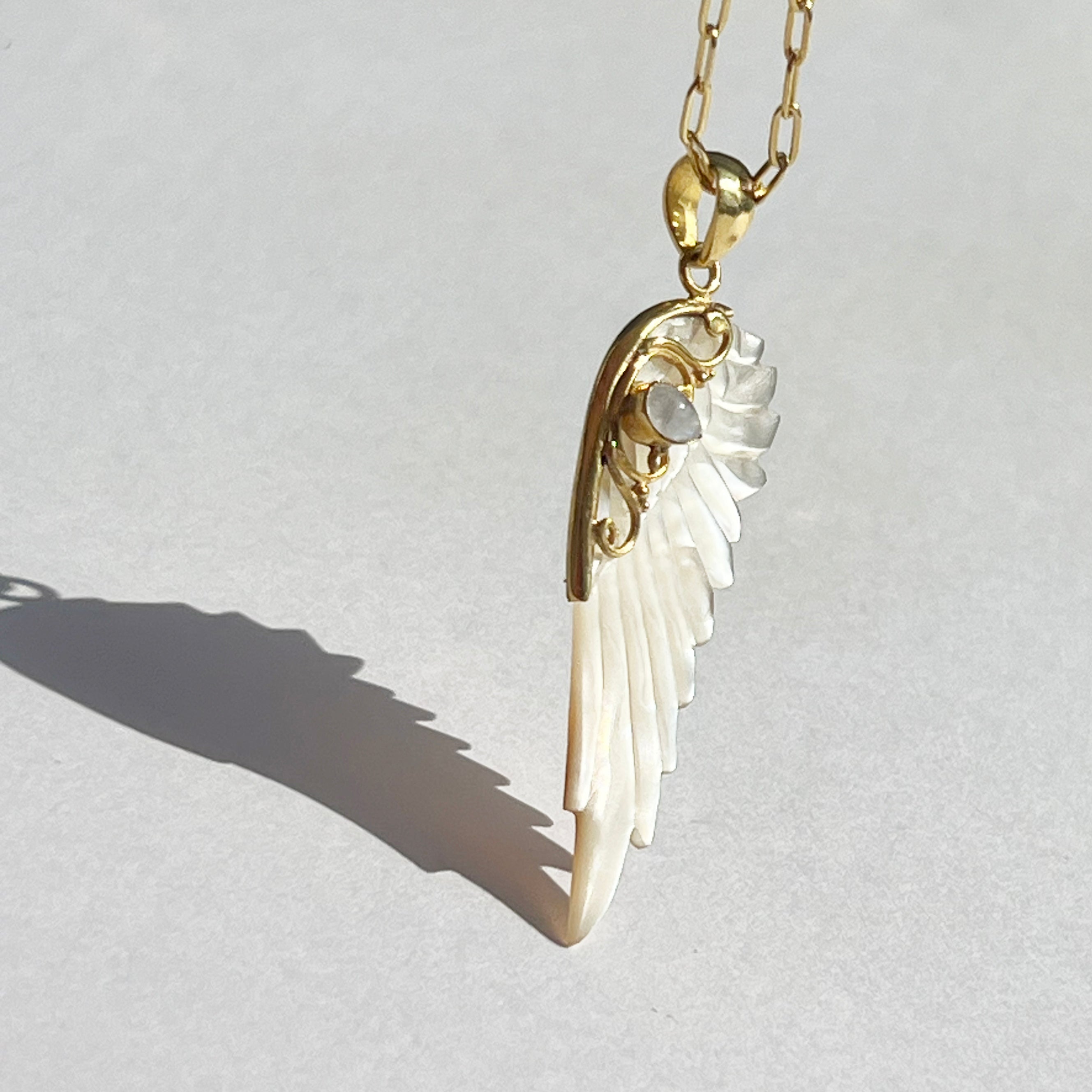 Gold hand carved wing necklace with mother of pearl pendant and moonstone detail on 18kt gold plated sterling silver chain, statement jewellery by Angel Rocks