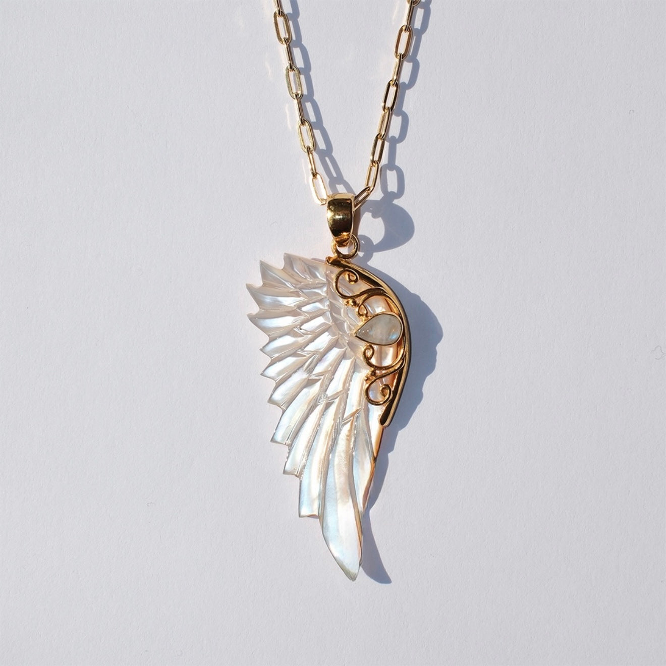 Gold hand carved wing necklace with mother of pearl pendant and moonstone detail on 18kt gold plated sterling silver chain, statement jewellery by Angel Rocks