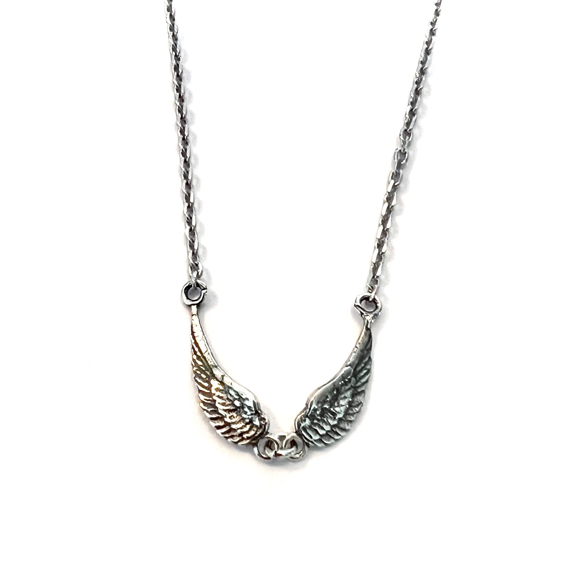 Sterling silver tiny angel wings necklace with small oxidised wing charms on adjustable fine chain by Angel Rocks