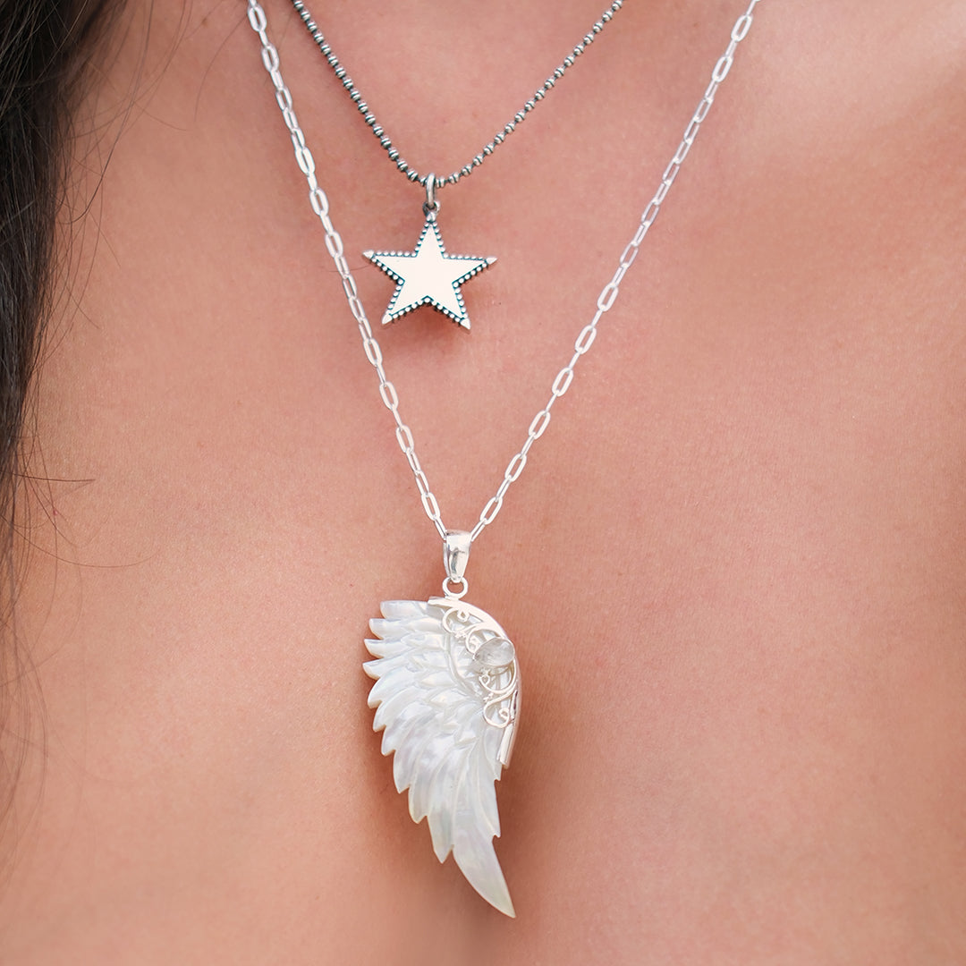 Sterling silver hand carved wing necklace with mother of pearl pendant and moonstone detail sterling silver chain, styled with silver rock star necklace, statement jewellery by Angel Rocks
